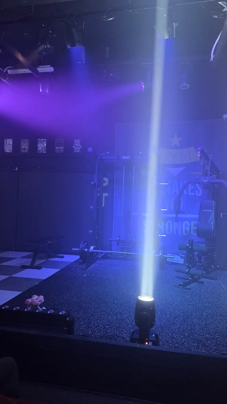 분홍 덤벨과 LED 바 조명이 놓인 무대 앞쪽