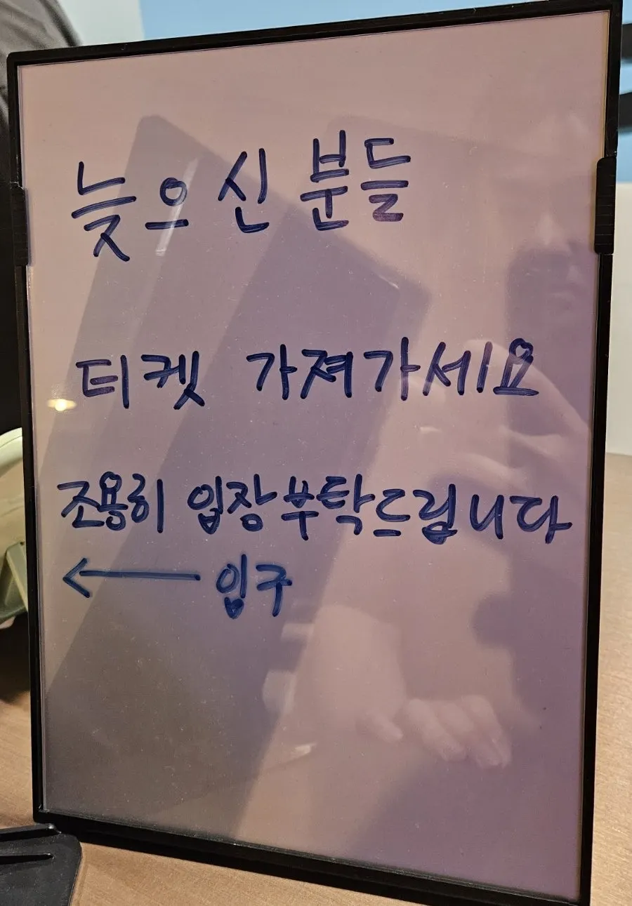 Vertical photo of a sign explaining late-entry rules at the theater