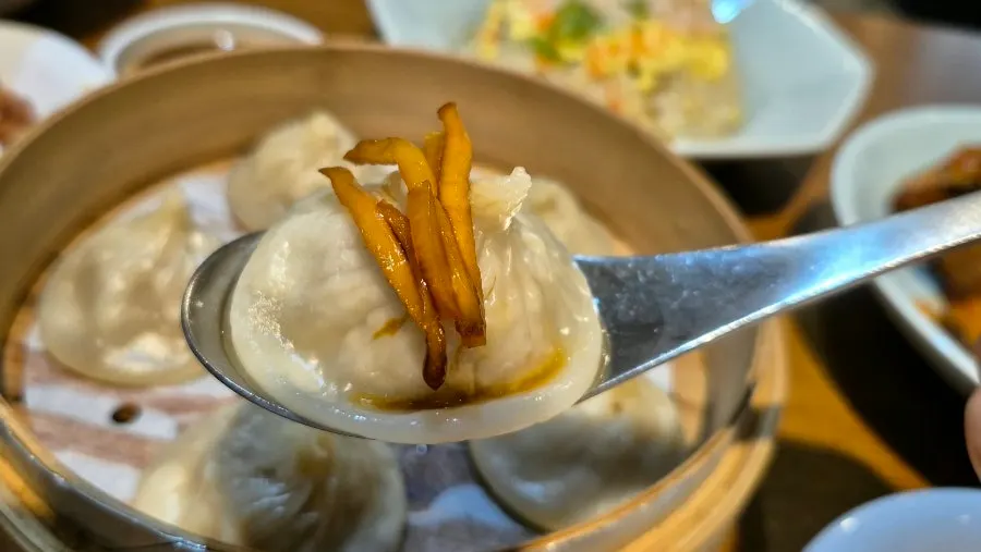 Xiaolongbao topped with shredded ginger, ready to eat