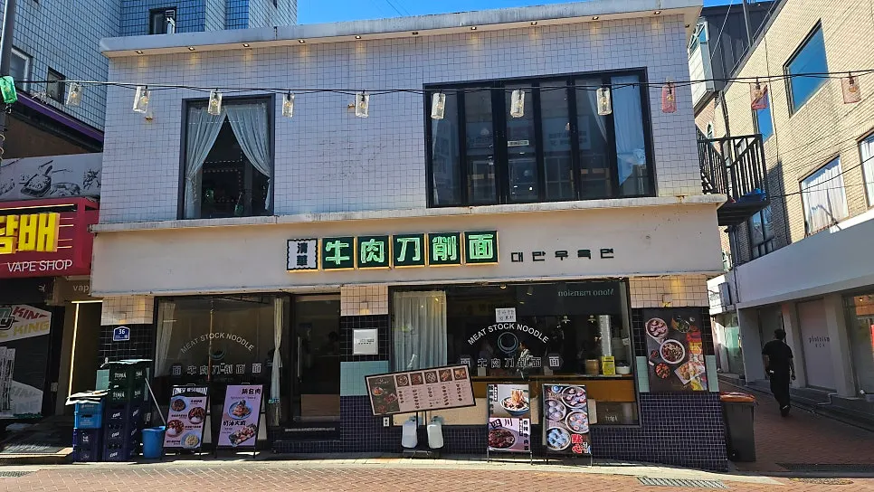 흰색 타일 외관에 초록색 한자 간판이 있는 청화원 대학로점