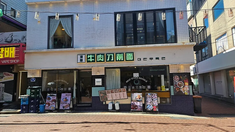 음식 사진과 메뉴판이 붙은 청화원 대학로점 매장 전면