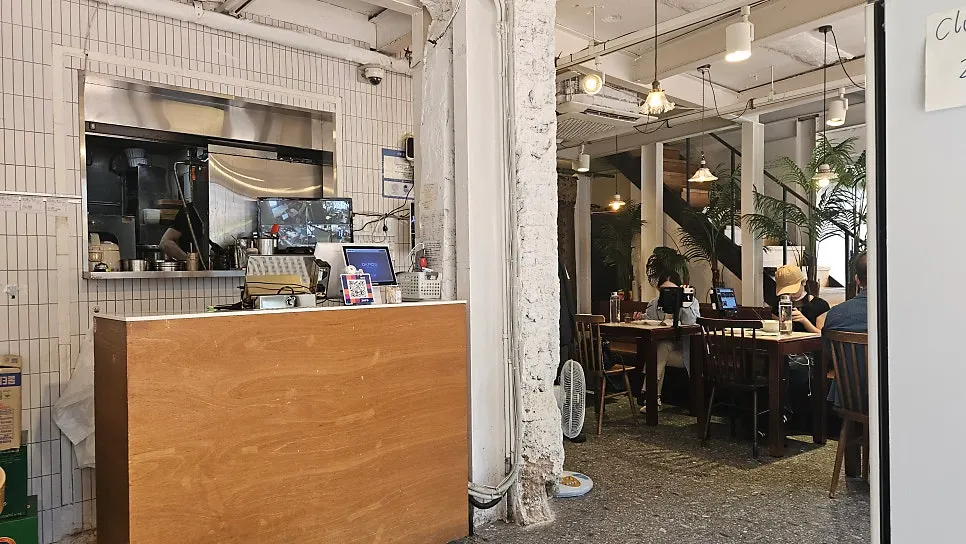 화이트톤 벽과 나무 테이블의 청화원 대학로점 내부