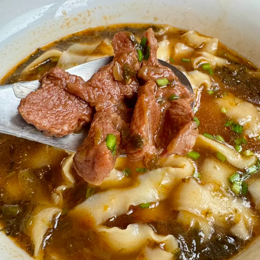 Chewy knife-cut noodles lifted up with chopsticks