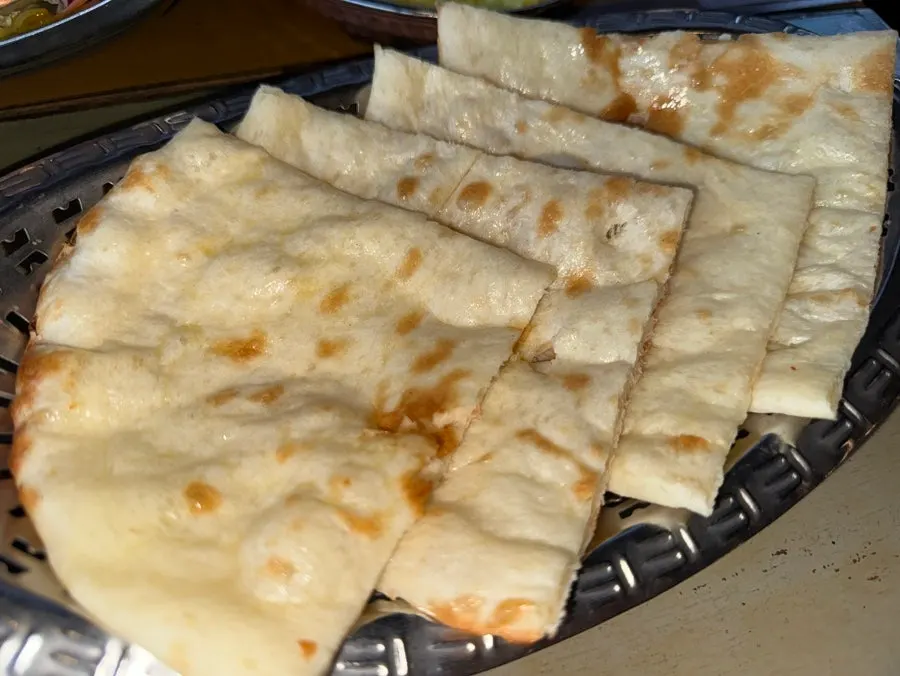 Butter naan being dipped into curry