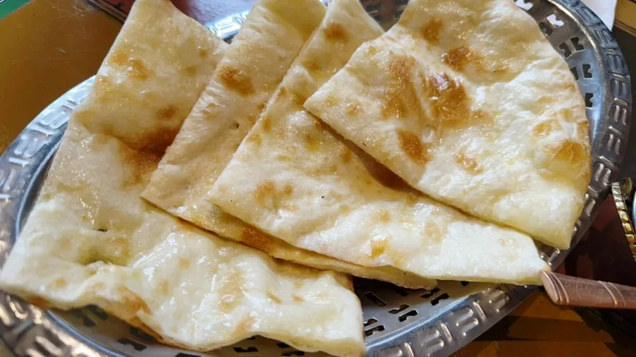 Charred naan served alongside curry