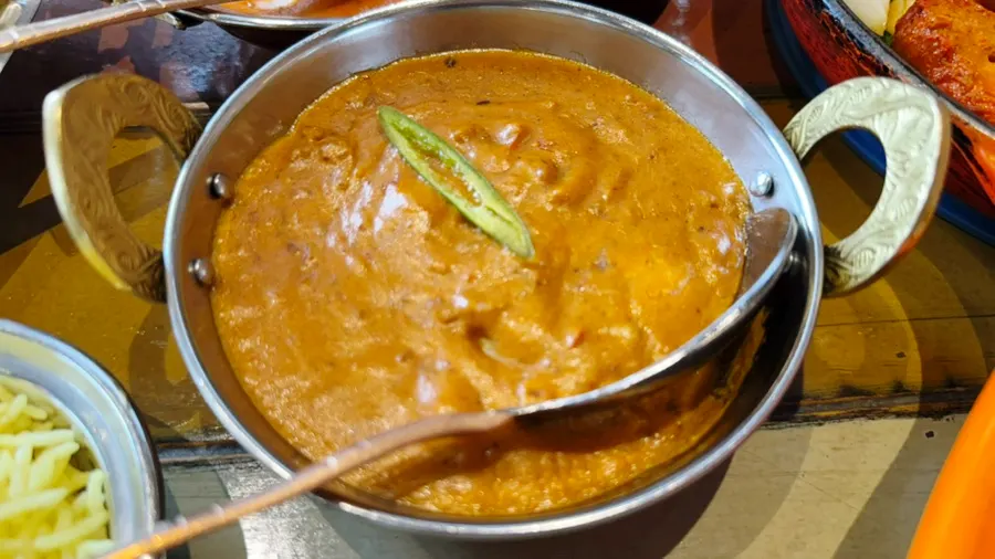 Dipping naan into prawn makhani