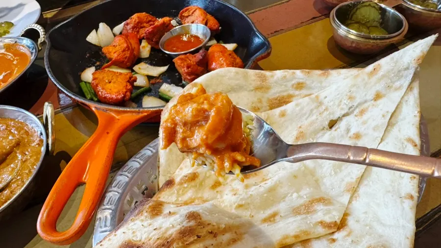 Spread of two curries, naan, and rice combinations