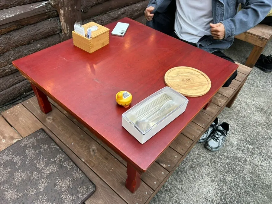 Outdoor raised wooden-platform seating at Gongjung Dodeok