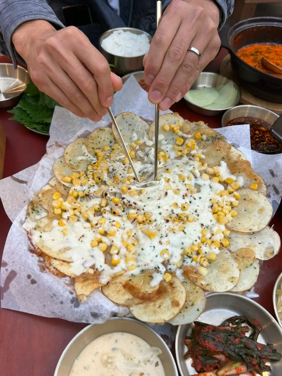 Cheese potato pancake topped with potato slices and sweet corn