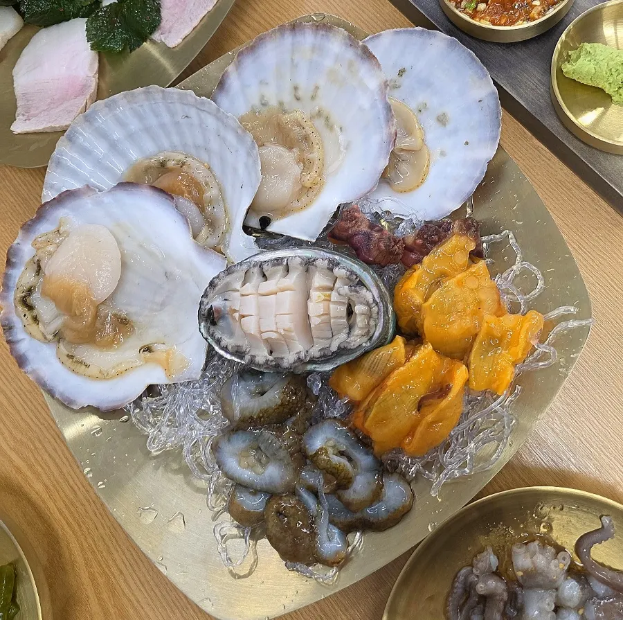 Plate of mixed seafood with abalone, scallop, sea cucumber, and sea squirt