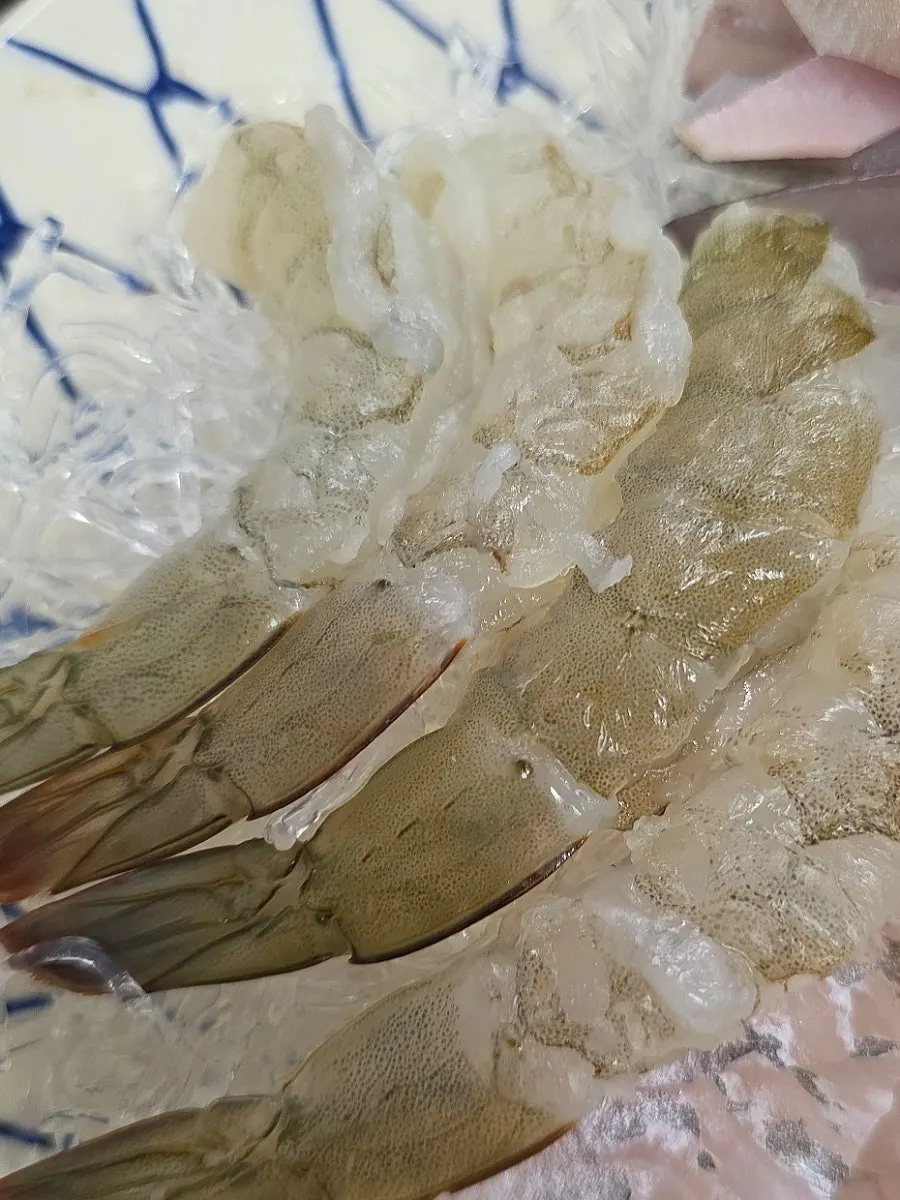 Plate of translucent raw shrimp sashimi