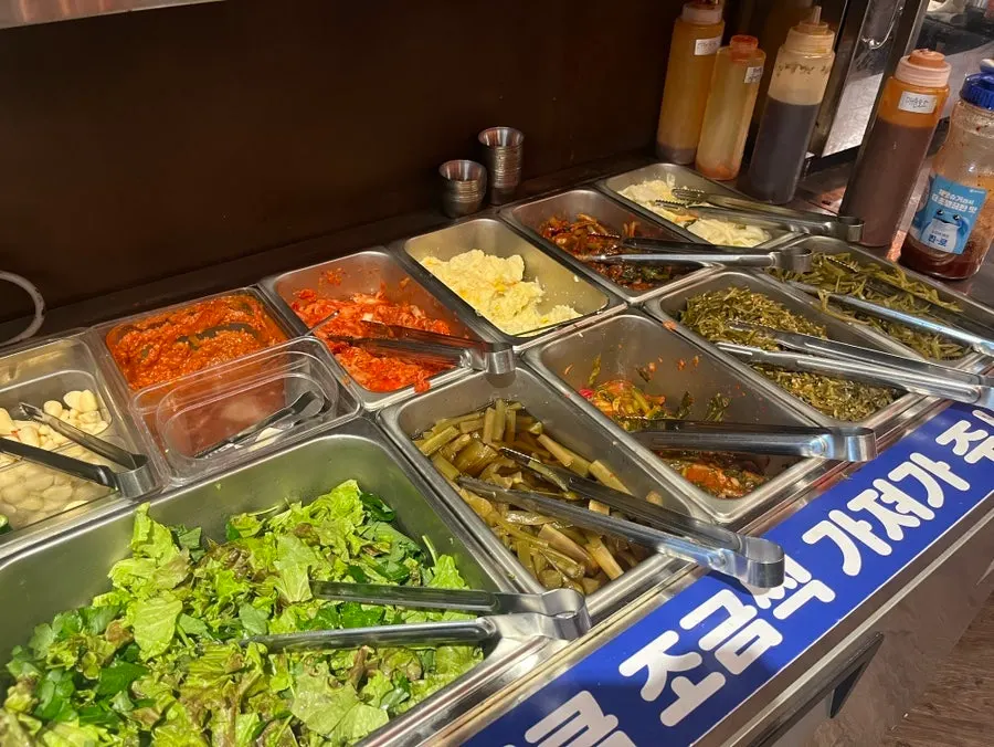Self-serve bar with wrap greens and side dishes