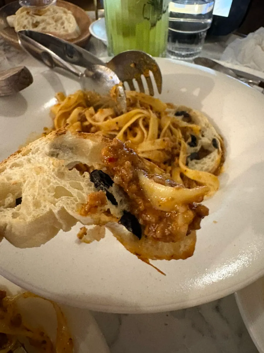 Olive ciabatta topped with ragu sauce