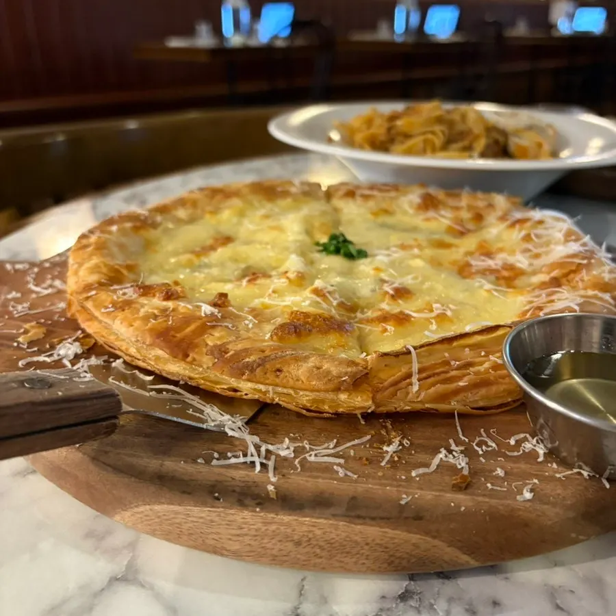 A slice of gorgonzola pizza with honey drizzle