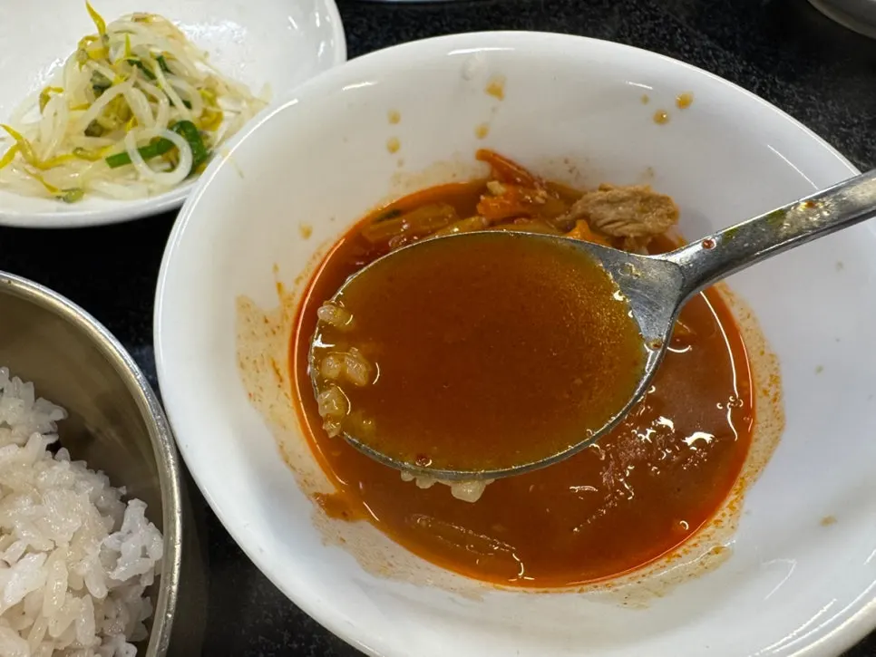 A spoonful of hot kimchi stew broth