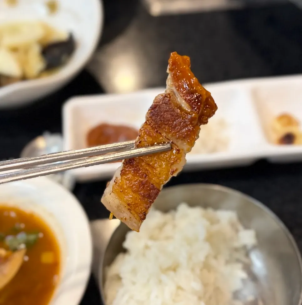 Golden grilled pork belly on a cast-iron lid