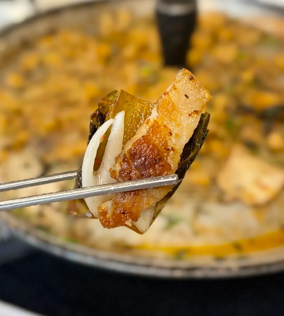 Aged kimchi and scallion salad atop pork belly