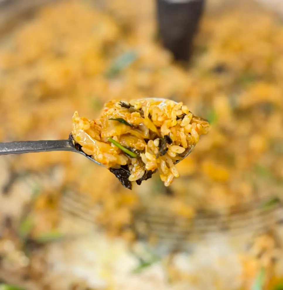 Kimchi fried rice cooking on a cast-iron lid