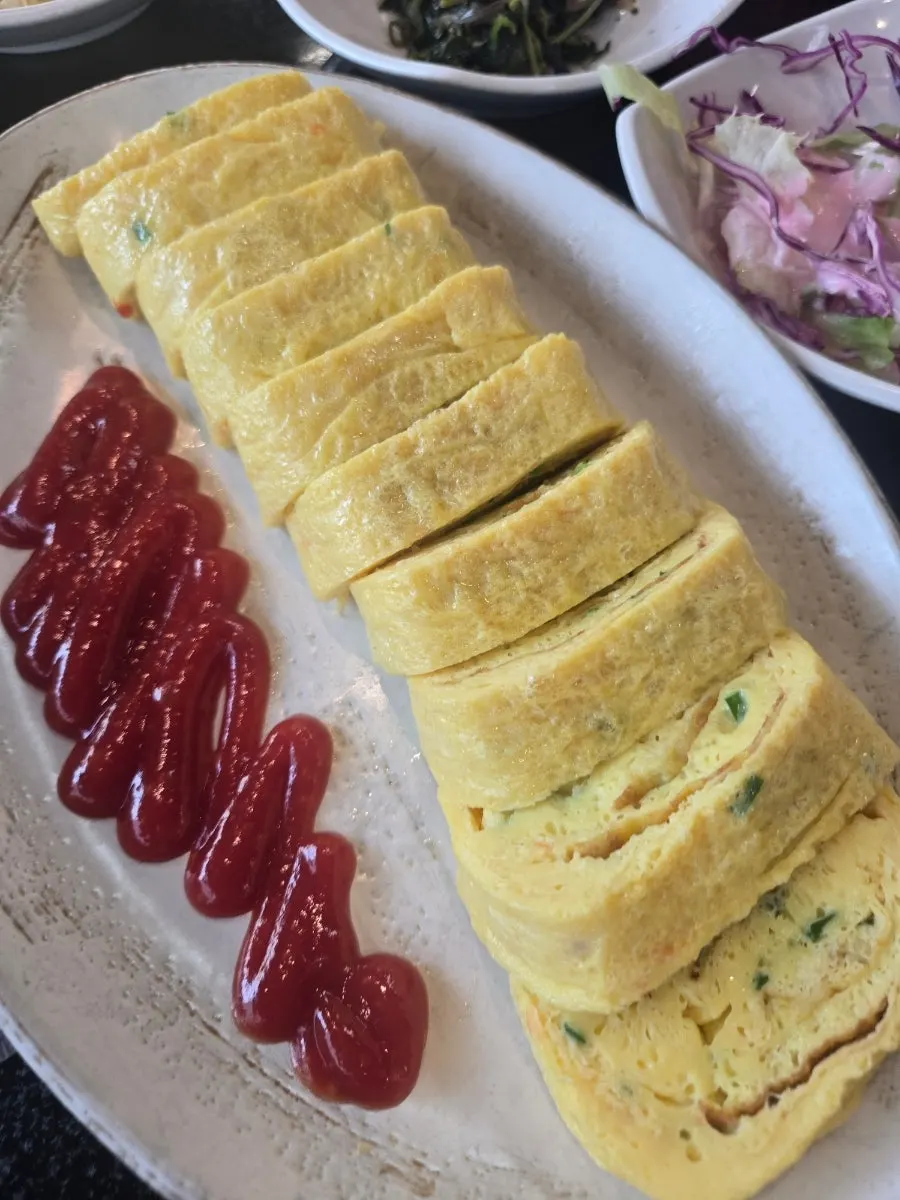 Thick, moist egg roll with Korean side dishes