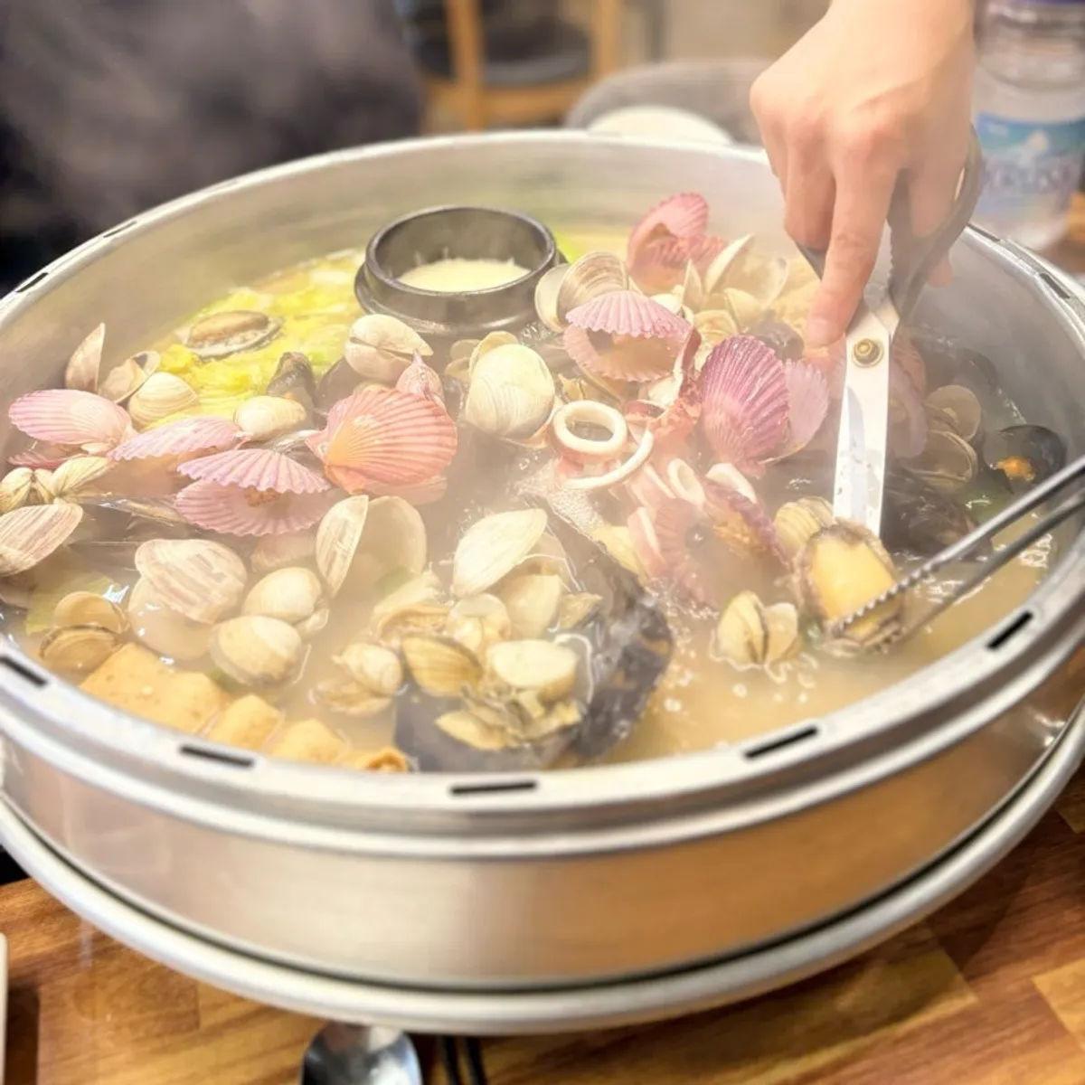 The lid lifted, revealing the clams in the hot pot
