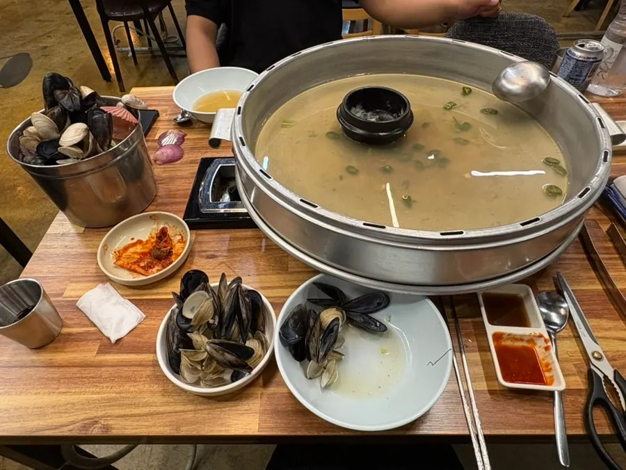 The nearly empty kalguksu pot alongside finished banchan