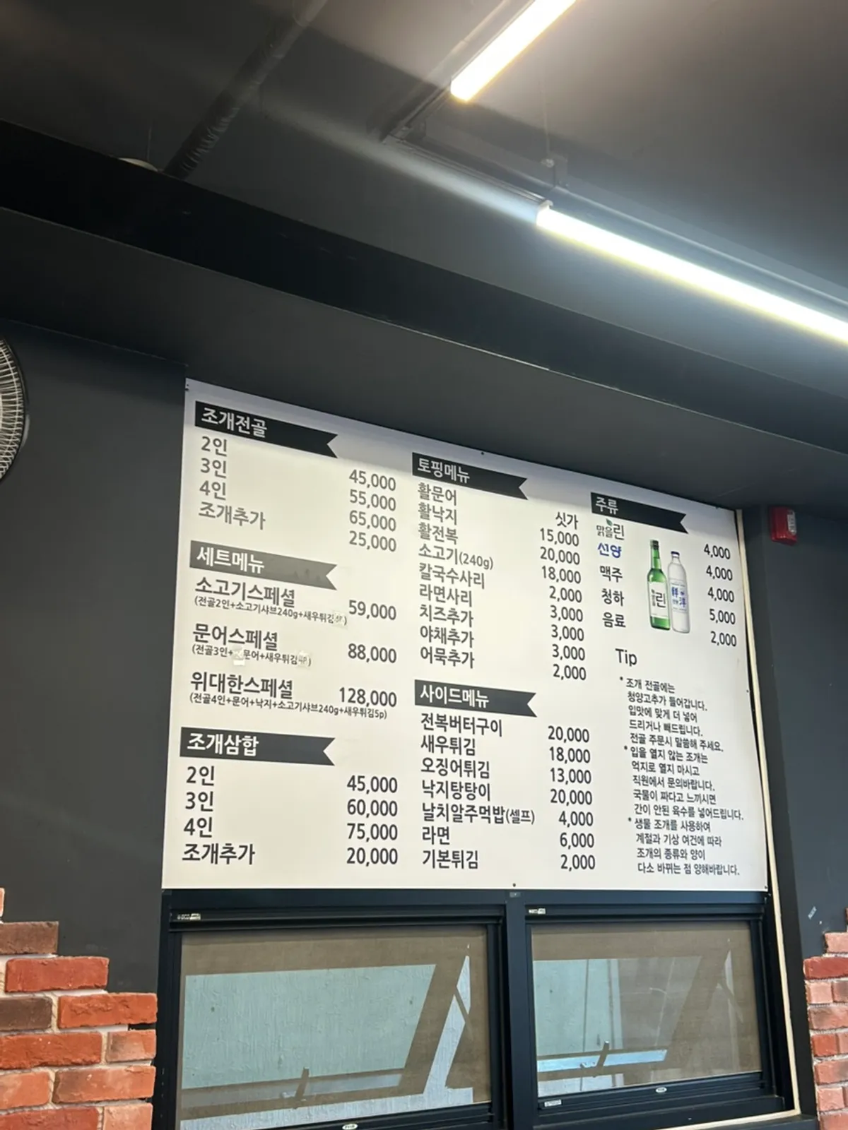 Menu board for clam hot pot and side dishes at Widaehan Jogae Jeongol