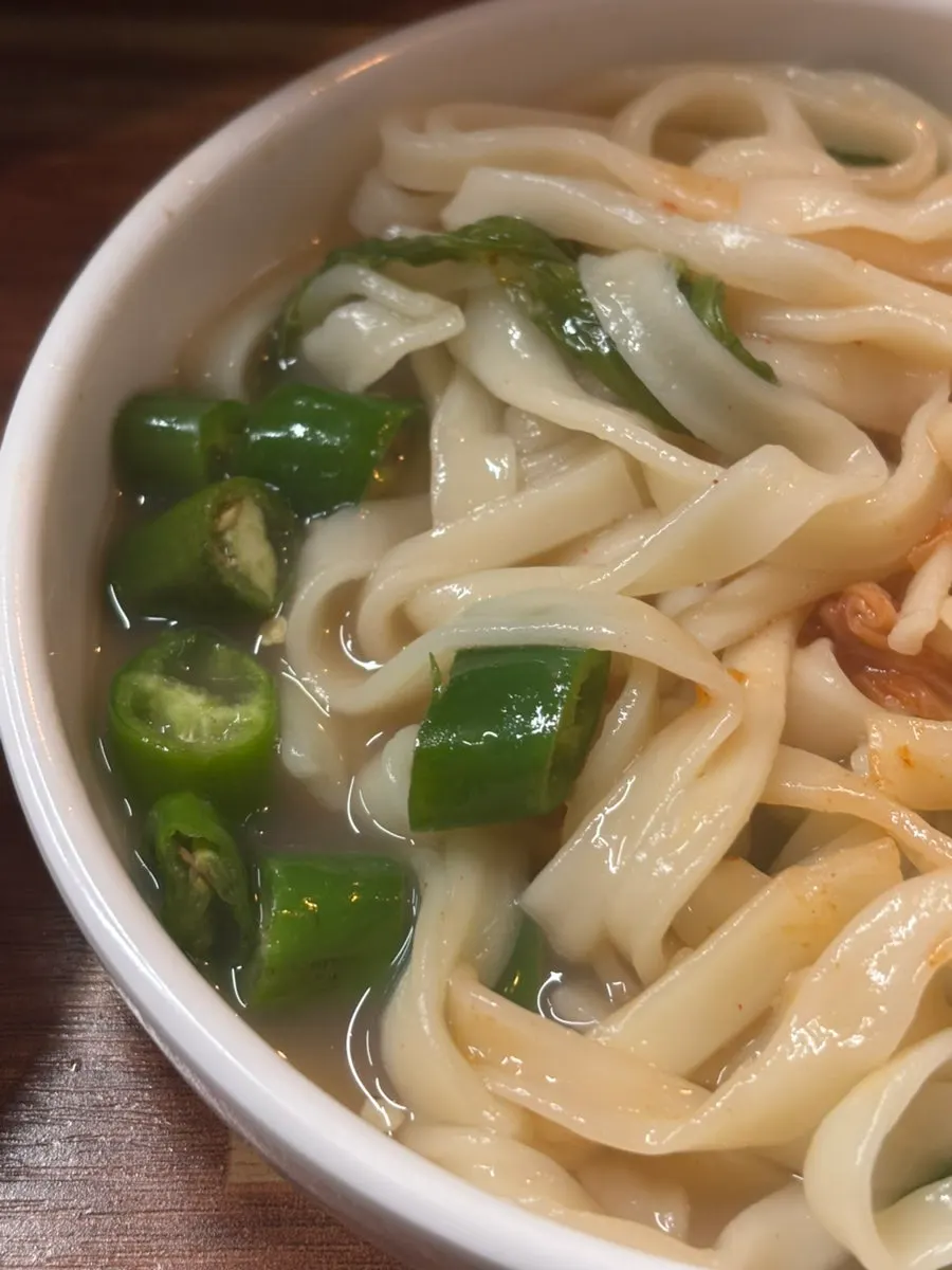 A bowl of kalguksu with fresh-mixed kimchi