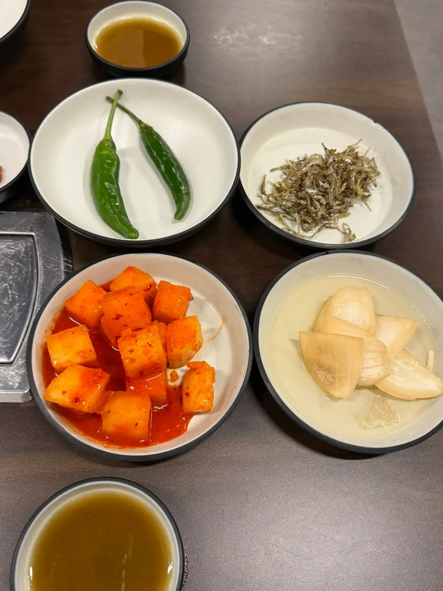 Side dishes including stir-fried anchovies at the gamjatang restaurant