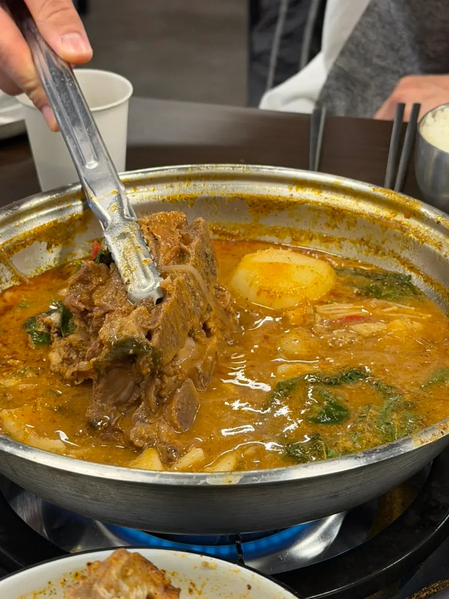 A bite of gamjatang meat eaten with rice