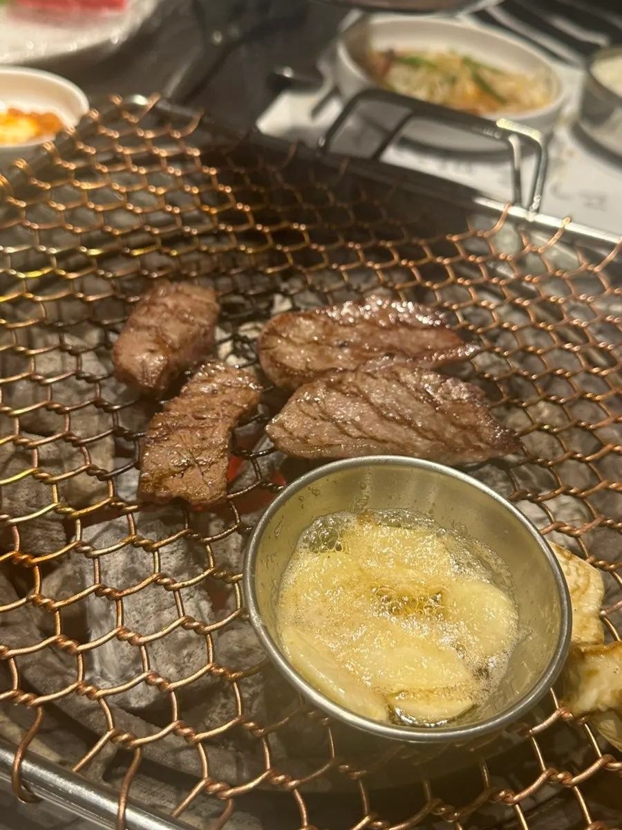 A piece of hanwoo with wasabi and garlic