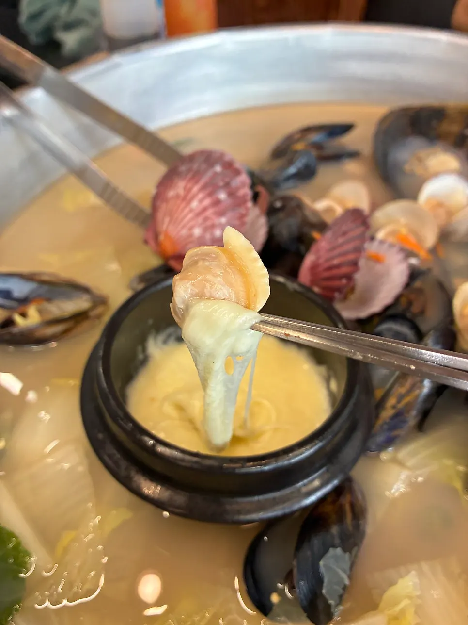 Lifting up cheese from inside the hot pot