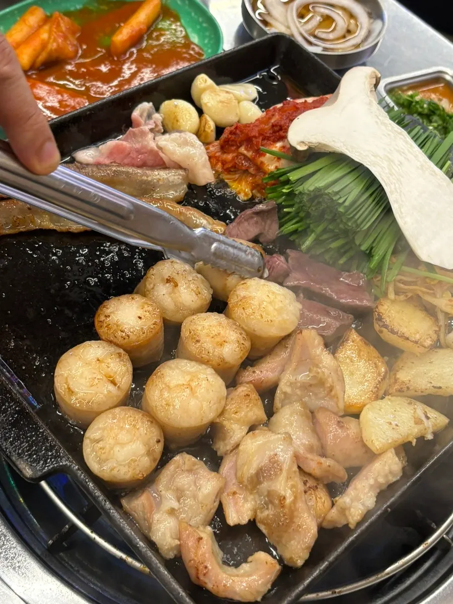 Mixed gopchang and vegetables cooking on the grill