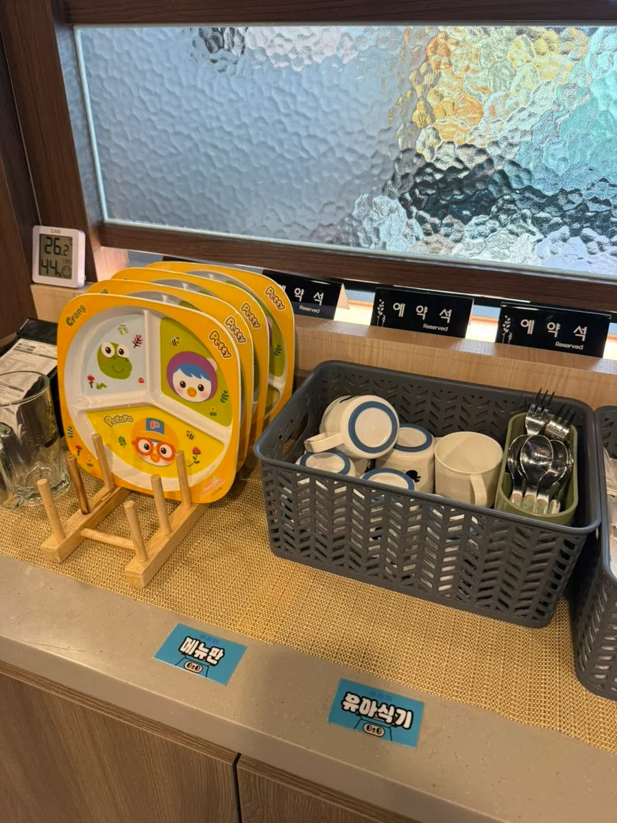 Corner with phone chargers, baby dishware, and disposable aprons