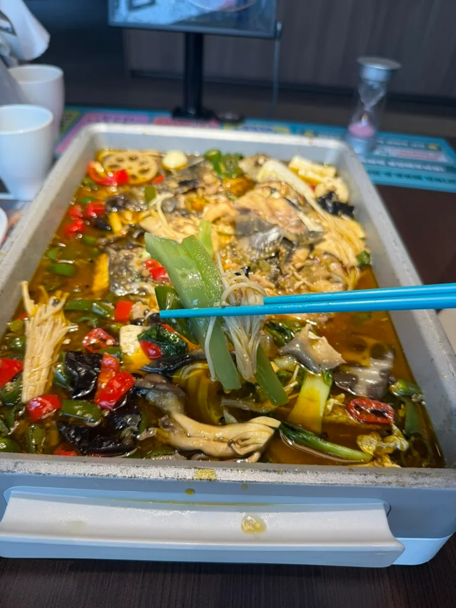 Plate of cooked mushrooms and vegetables scooped from the pot