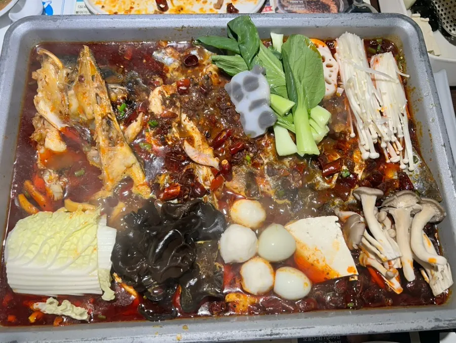 Mala kaoyu fish being dipped into sauce