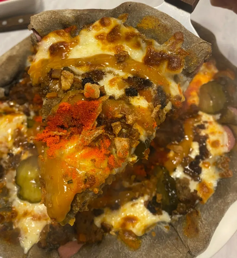 Pizza topped with beef and cheddar cheese