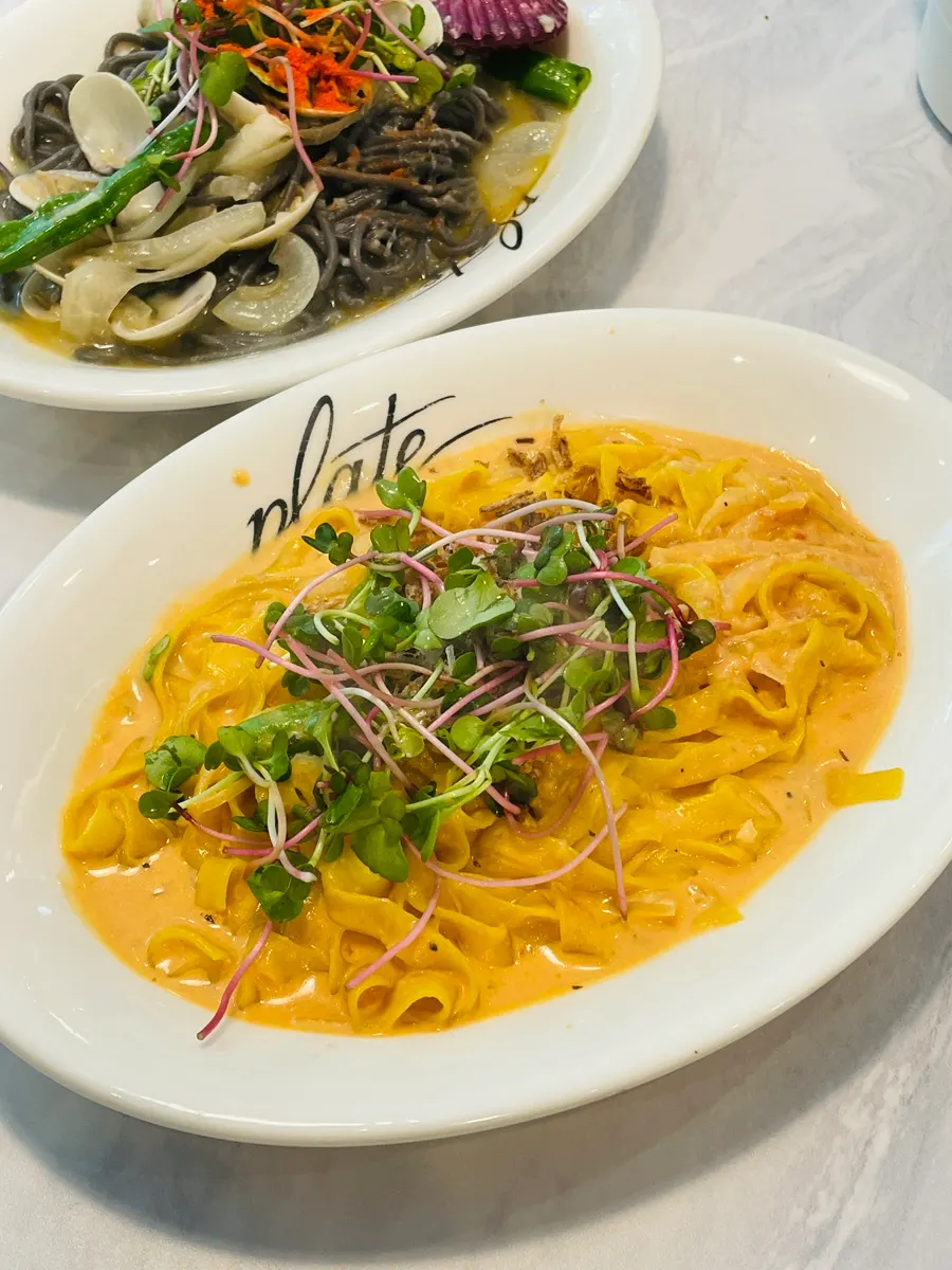 くるくる巻いて盛り付けたイカ墨生麺のボンゴレ