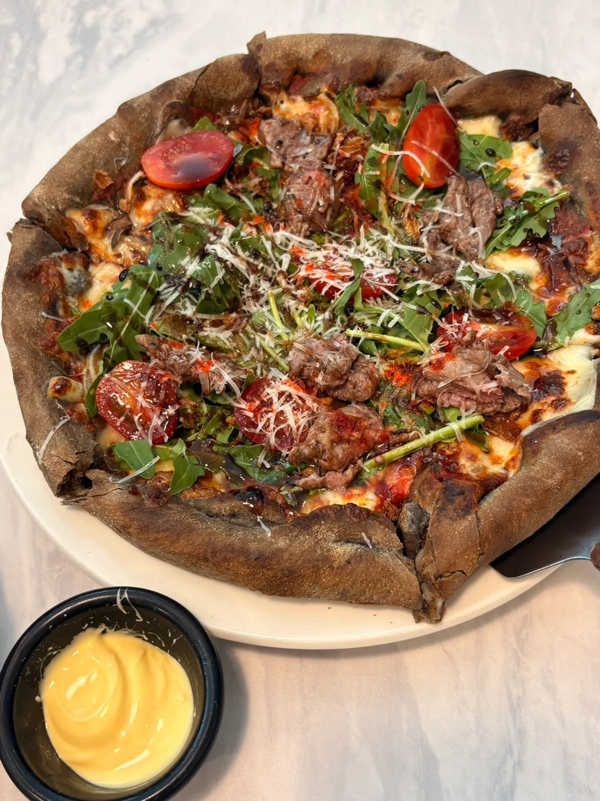 Fire-grilled chapsteak pizza with stretchy cheese