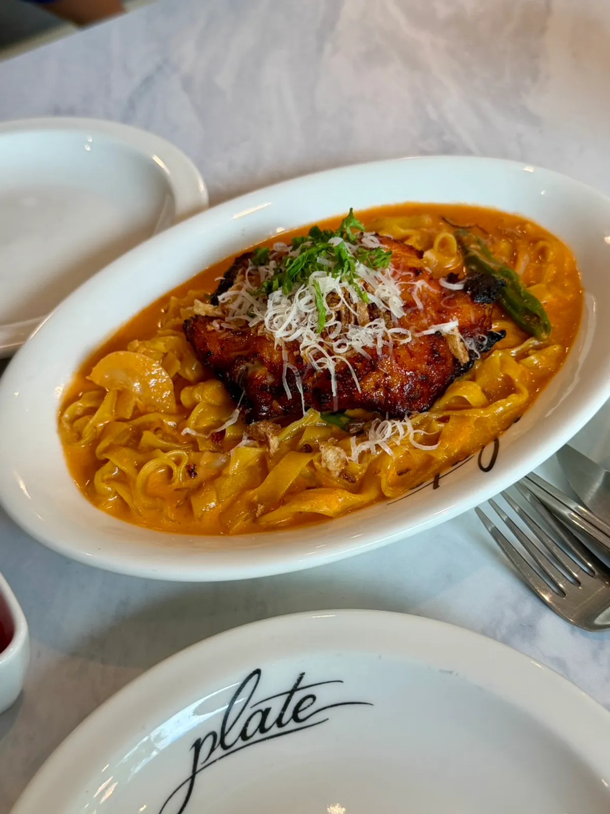 A table with long-leg fire chicken rosé pasta and fire-grilled chapsteak pizza
