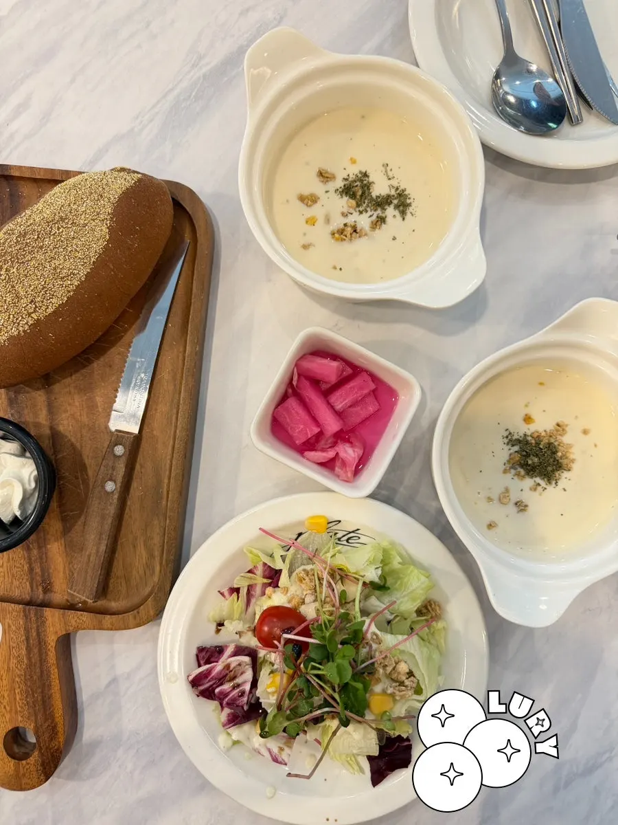 Soup, salad, and bread served with the steak set