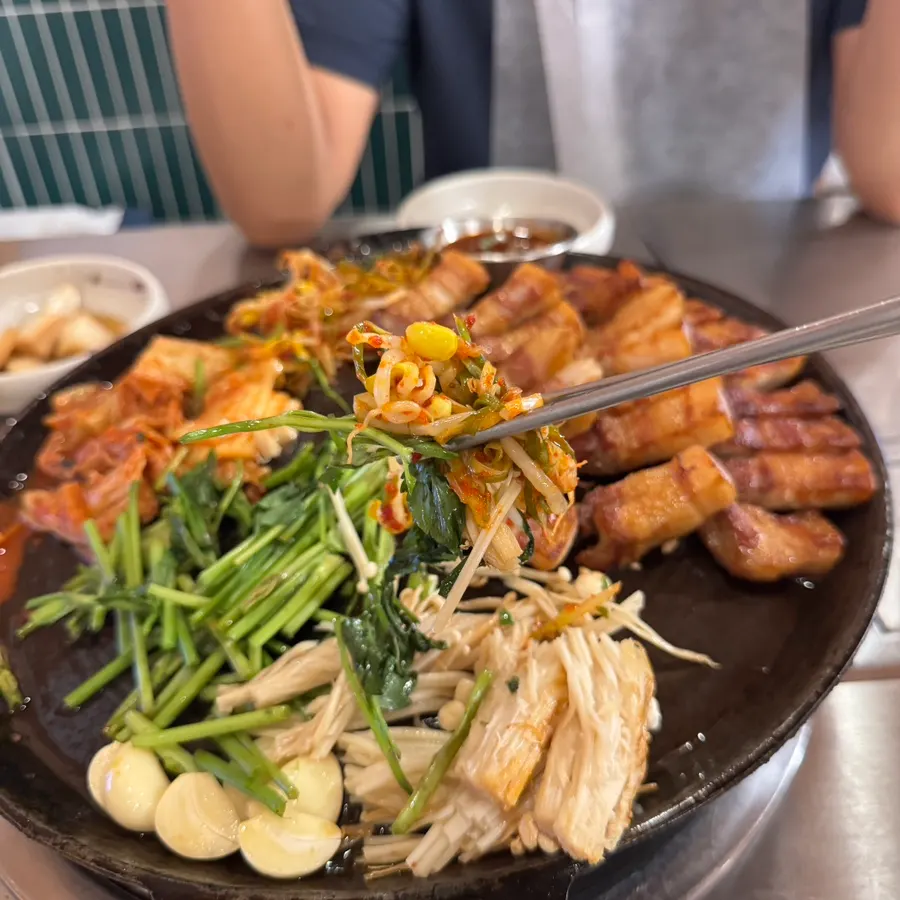 Grilled platter topped with minari and enoki mushrooms