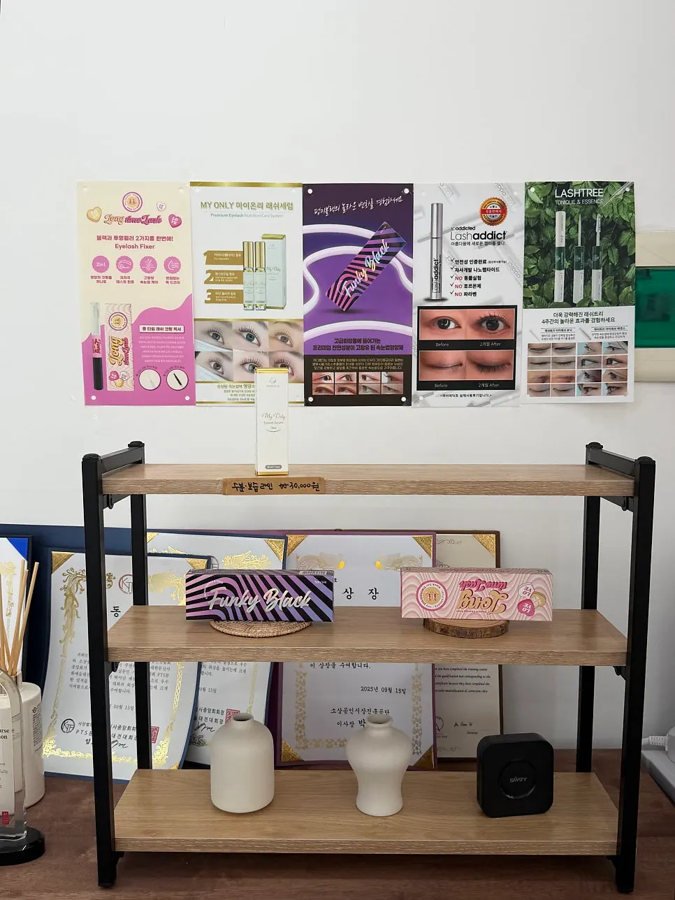 Lash serum poster and certificates on the wall