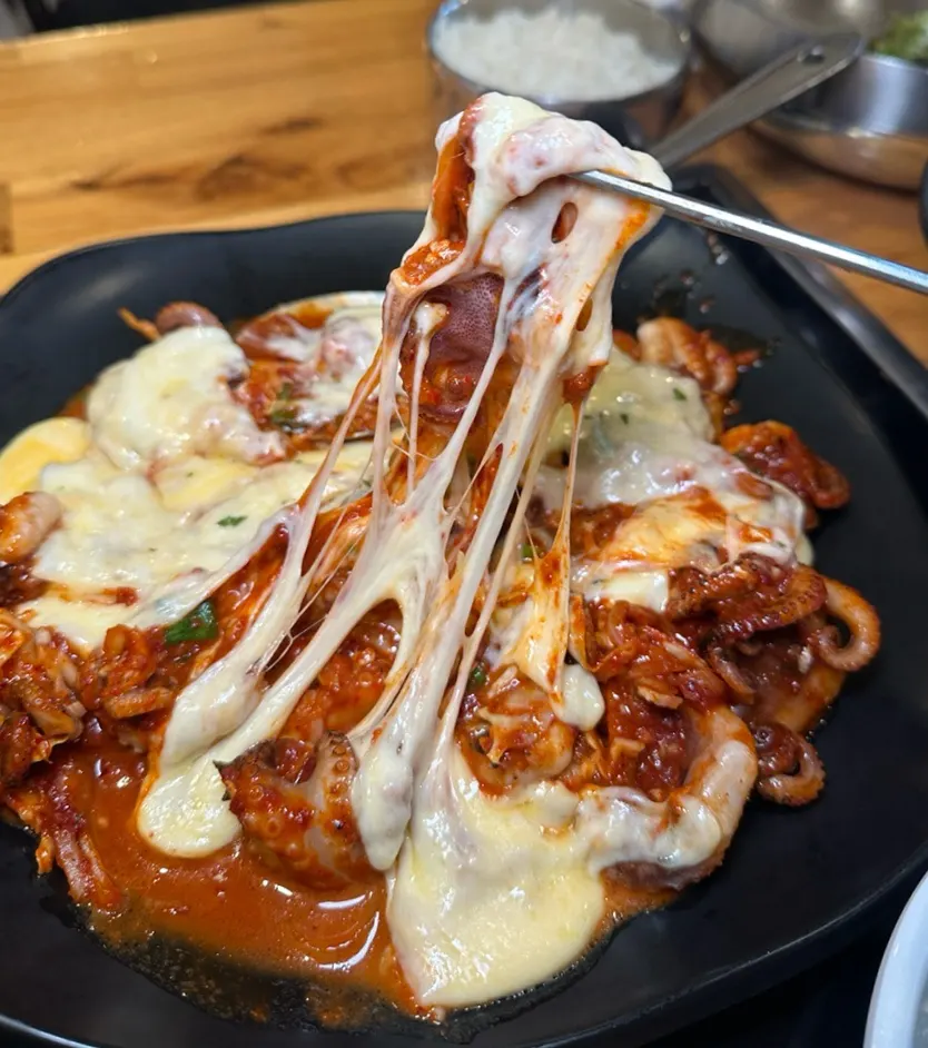 Melted cheese over spicy octopus sauce