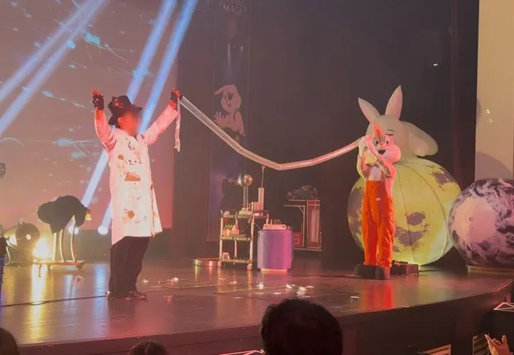 A dad from the audience blowing up a plastic bag during the air pressure experiment