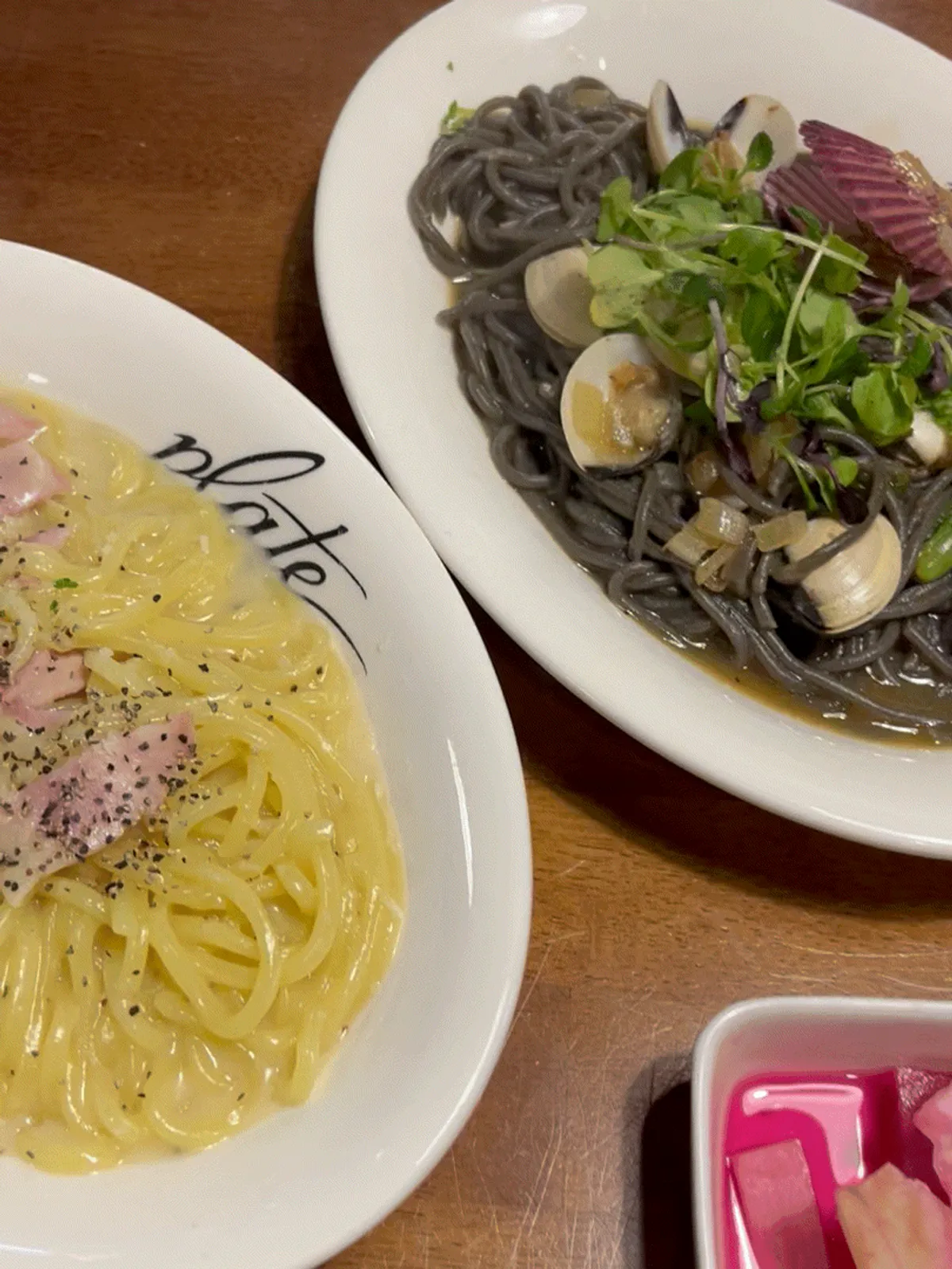 Two plates: ink white vongole and piche cacio e pepe