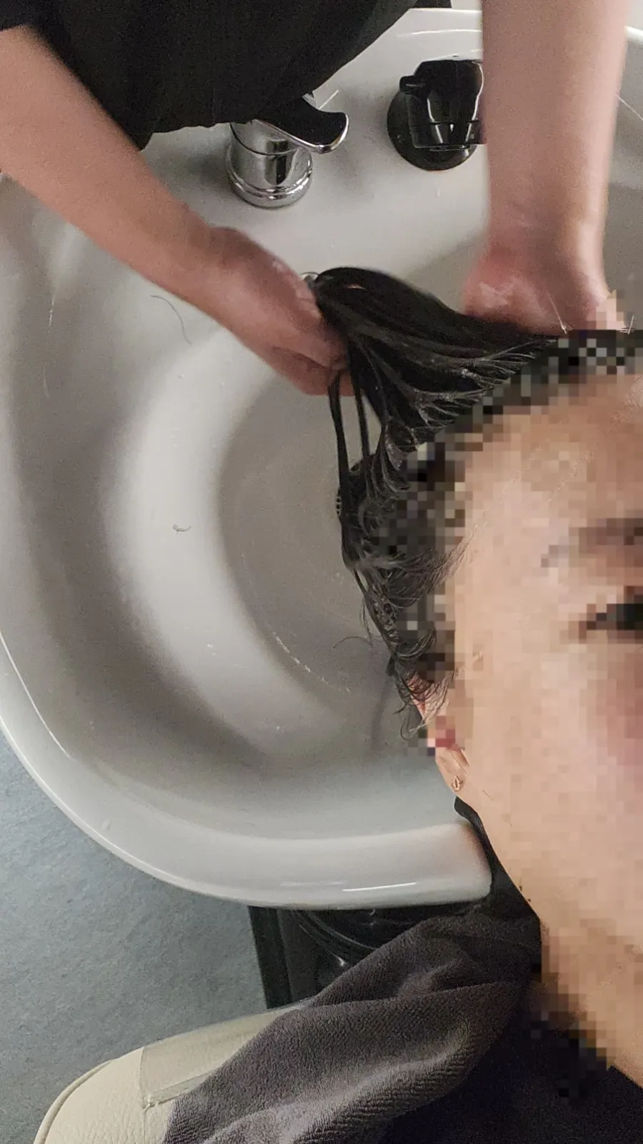 모발 잔류 성분을 확인하며 약제를 바르는 손길