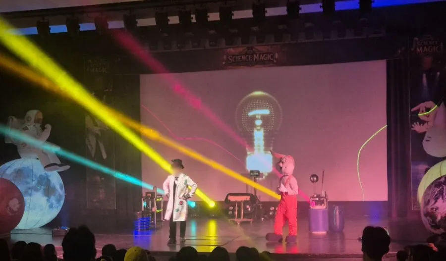 Audience participating in a science magic scene onstage