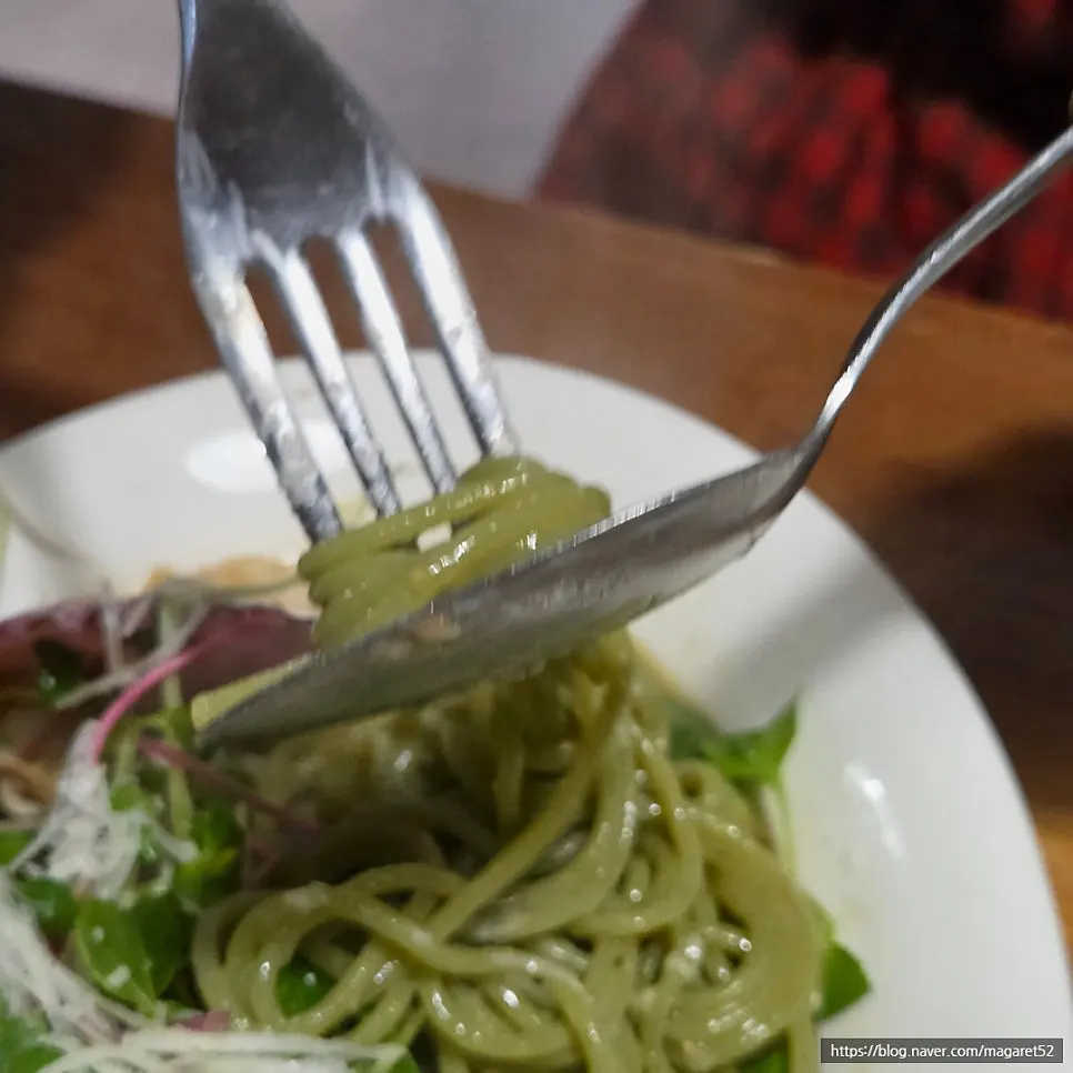 A bite of pasta with scallop scooped up