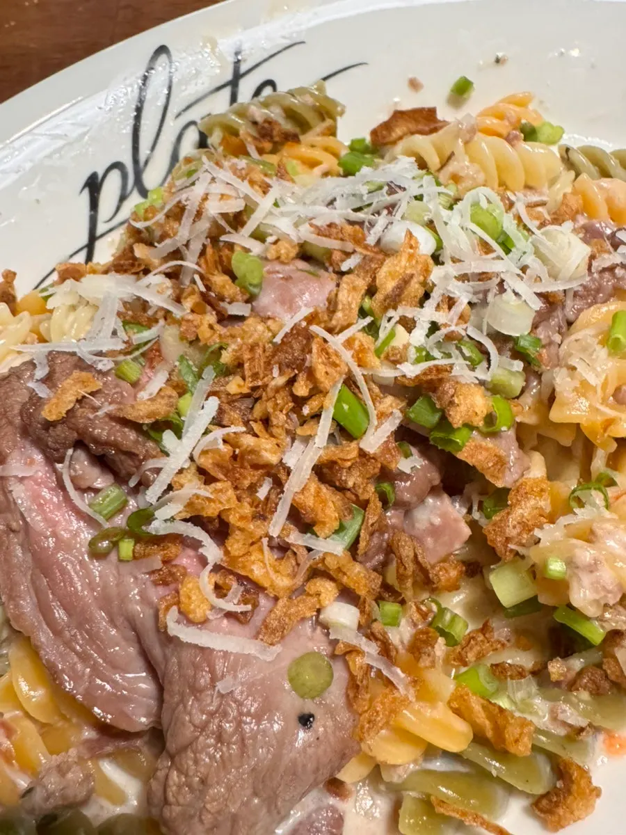 Ragù pasta combined with cream sauce and onion chips
