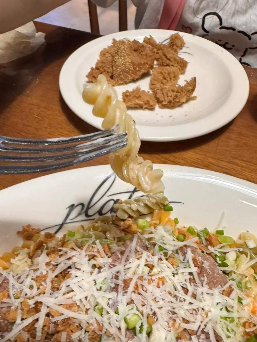 Fork lifting a bite of Plate's fresh pasta